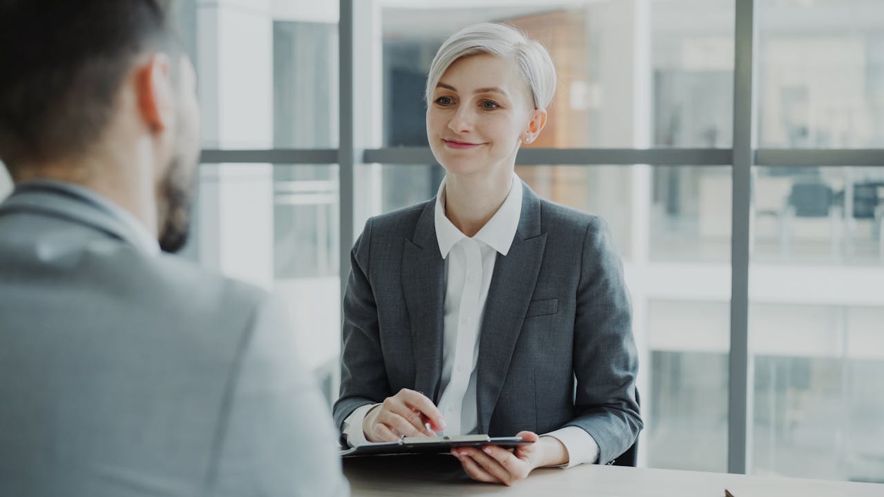 services-img Confident woman interviewing candidate in a modern office. Ideal for business and HR visuals.