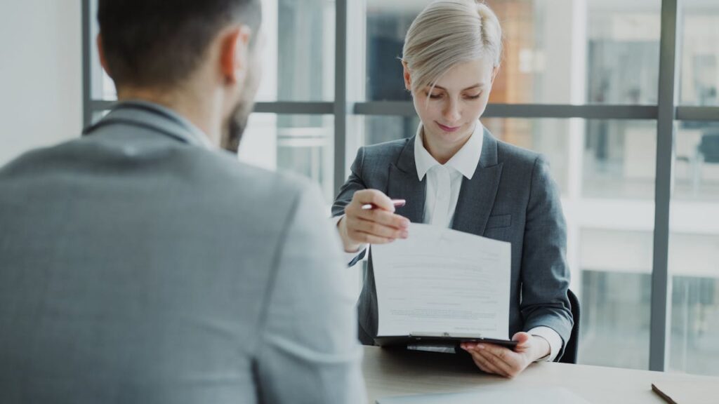 pexels-photo-36733329 Business professionals reviewing a contract in a modern office setting.