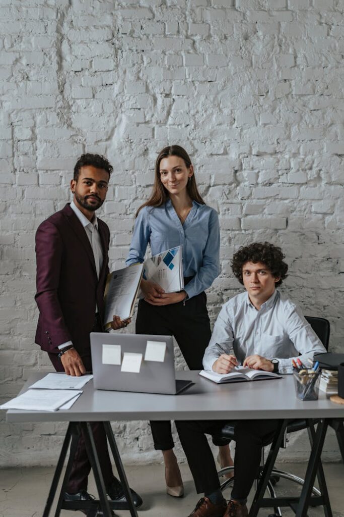 Three colleagues discussing plans in a modern office environment.