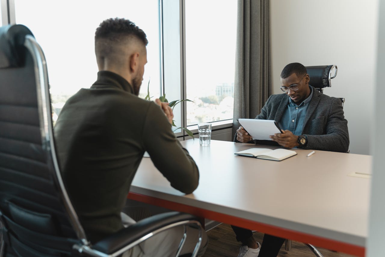 services-02 A job interview taking place in a modern office setting between two professional men.